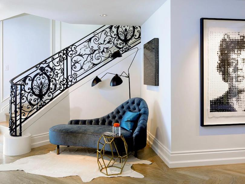 Entryway With Plush Chaise and Intricate Railing